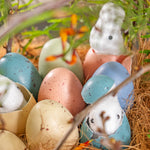 Colorful Easter eggs with decorative bunnies in a nest