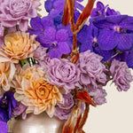 Bouquet of flowers with purple, orange, and pink colors on a light background