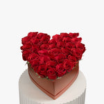 Heart-shaped box of red roses on a white background