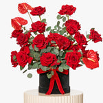 Bouquet of red roses with a black vase on a white background