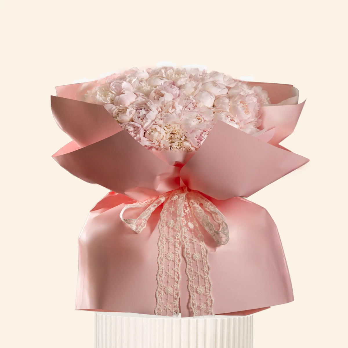 Decorative pink bow with lace details on a light beige background