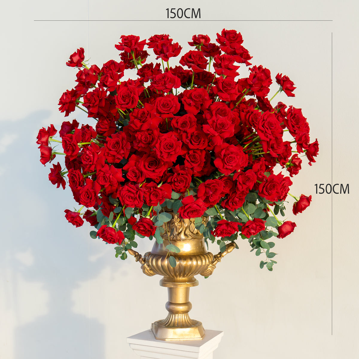 Bouquet of red roses in a gold vase on a white background