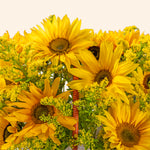 Bouquet of sunflowers in a woven basket against a light background