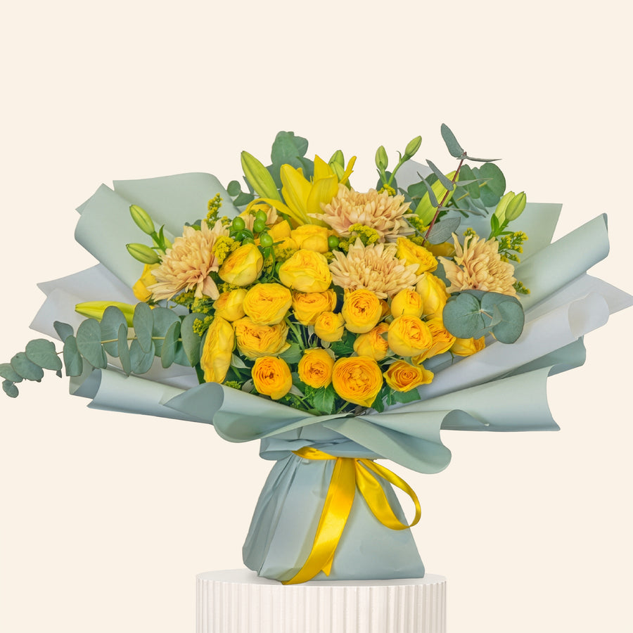 Bouquet of yellow flowers with greenery on a light beige background