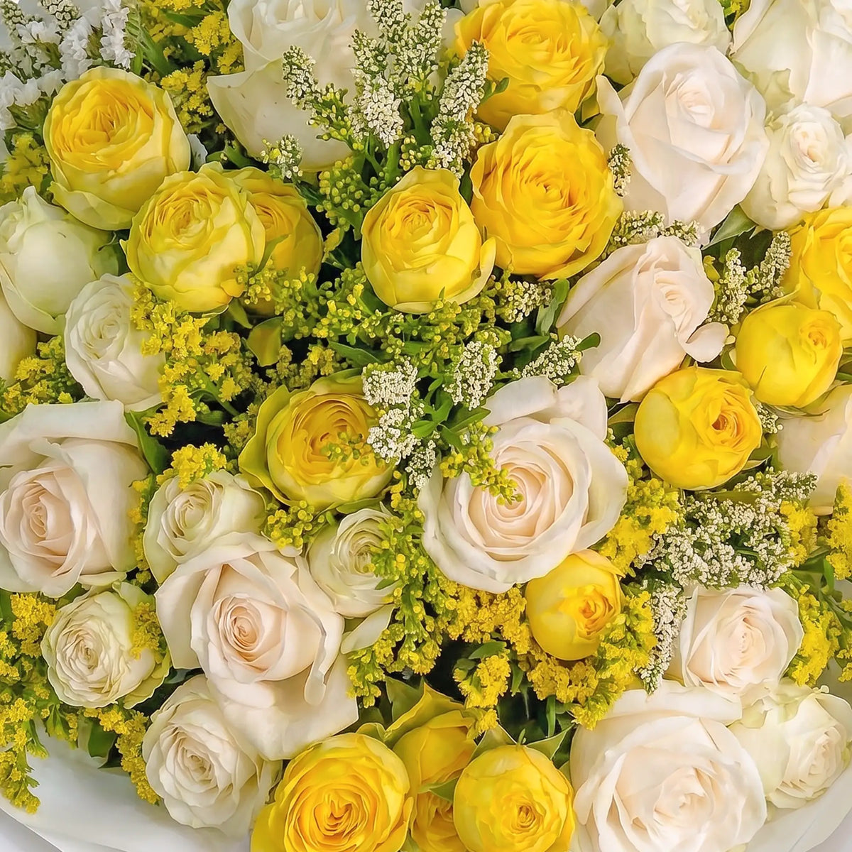 Bouquet of yellow and white roses with greenery
