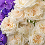 Bouquet of white and purple flowers including roses and orchids.