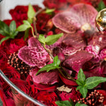 Close-up of a bouquet with red and purple flowers and green leaves.