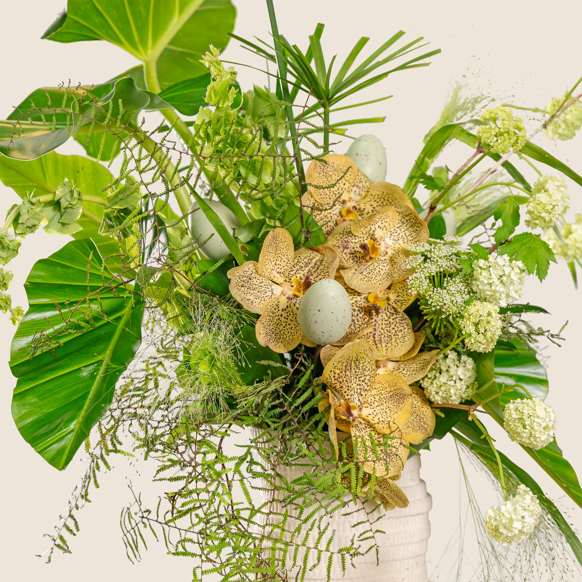 Bouquet of gold orchids and greenery on a white background