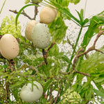 Decorative eggs on a branch with a natural background