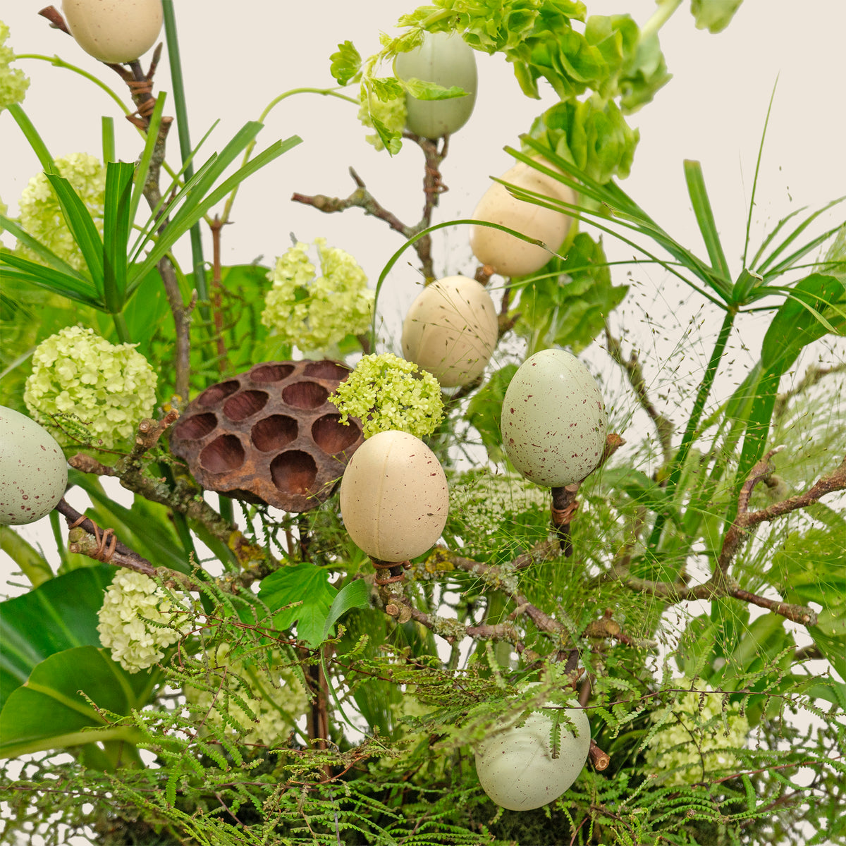 Decorative arrangement with eggs and greenery on a white background