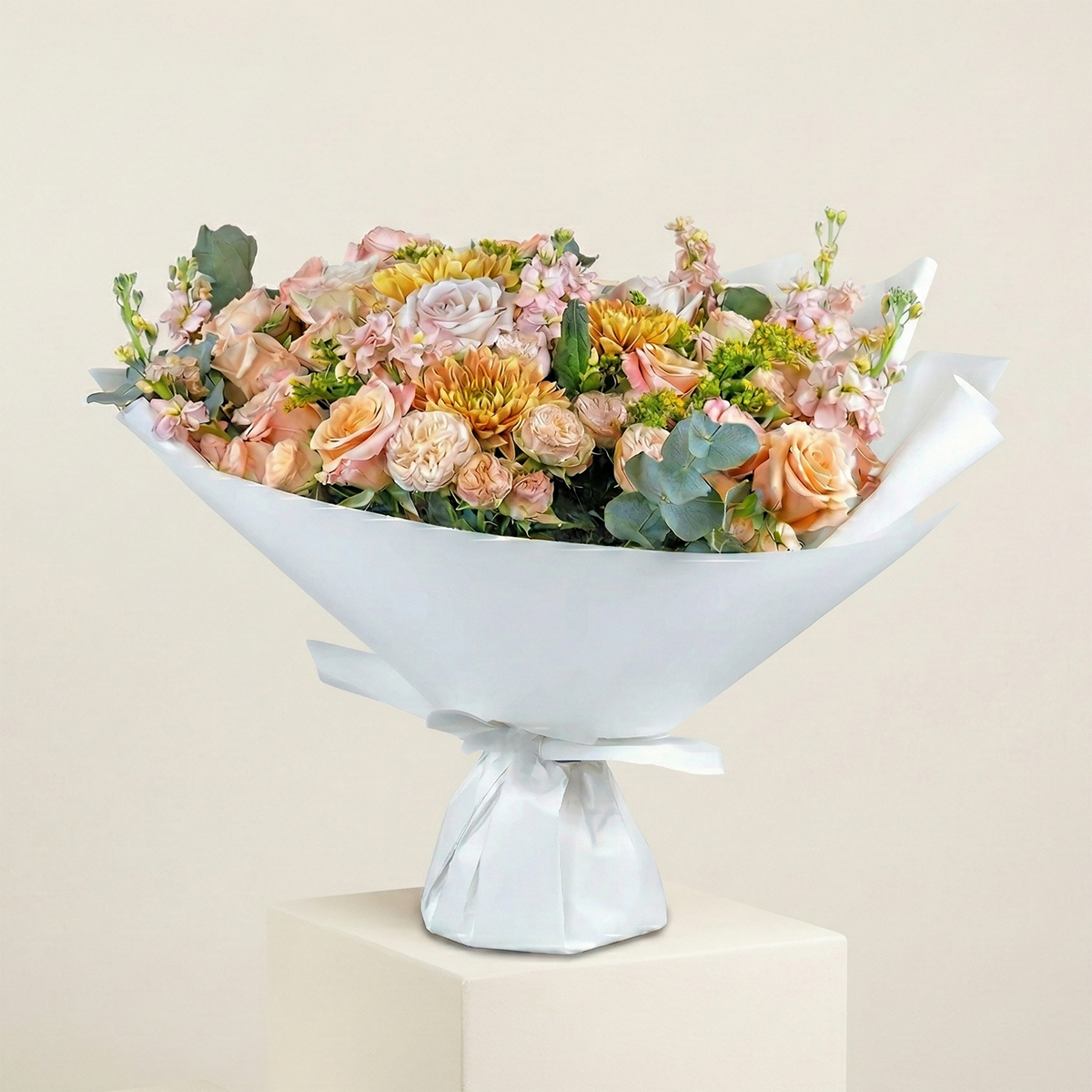 Floral arrangement in a white decorative bowl on a light beige background