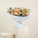 Bouquet of flowers in a white container on a beige background