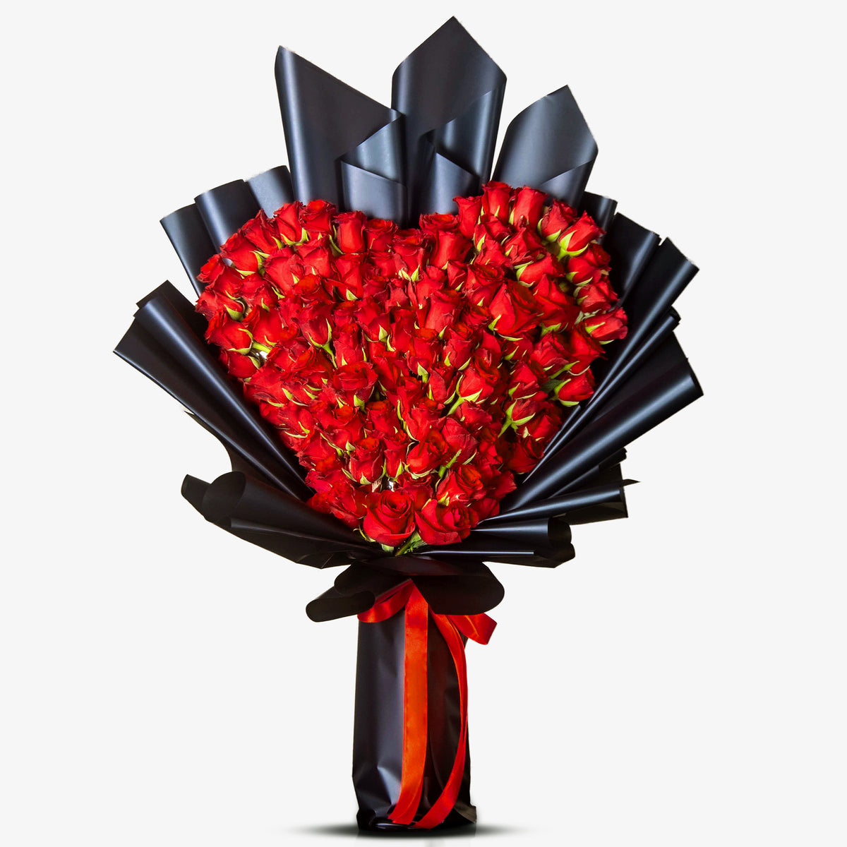 Heart-shaped bouquet of red roses wrapped in black paper with a red ribbon on a white background