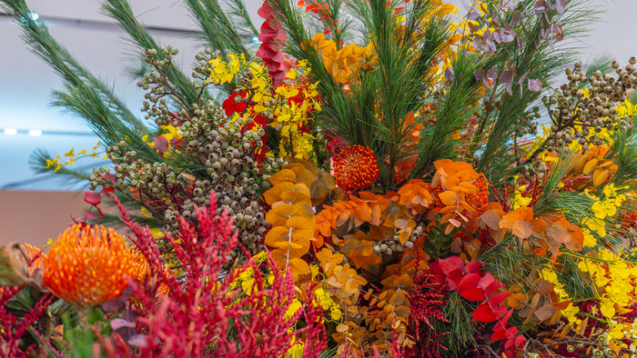 Colorful floral arrangement with orange, red, yellow, and green flowers.
